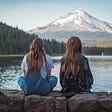We see two sisters staring at a faraway mountain. A unique moment of love and companionship.