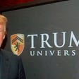 Donald Trump in front of Trump University sign.