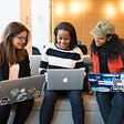 Three professional women on their laptops collaborating