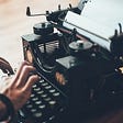 Typing on a typewriter.