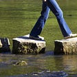 woman walking on stepping stones