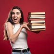 girl in white t-shirt holding a stack of 8 books against a maroon background