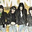 Relief art of Ramones in jeans and leather jackets made of fabric, wool and found objects.