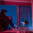 woman in black jacket sitting on window ledge
