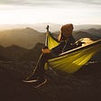 girl sitting in hammock looking at mountains