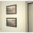 wall with two picture frames hanging centered