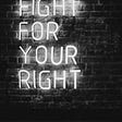 A neon sign on a brick wall reads: Fight for your Right