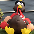 A large balloon turkey sitting on someone’s lawn