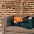 Man napping on a couch with a book over his face — Sleep to Improve Your Mental Toughness by Paul Myers