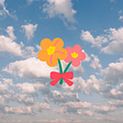 Bouquet of two flowers floating among nimbus clouds. The left flower is orange with yellow center and pink accents on petals. The right flower is pink with yellow center. Flowers have a pink bow tying them together.
