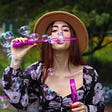 woman blowing bubbles in the park