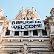 Building with banner reading ‘Refugees Welcome’ on it