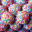 Pink balls of confectionery covered in multi-coloured hundreds and thousands.