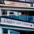A split photo showing a sign above a cafe reading coffees and cream. The upper sign has an apostrophe in the word coffees, and the lower photo is amended