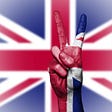 A photo of the British Flag with a hand that shows the peace sign.