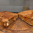 A toasted sandwich containing beans, cheese and hash browns.