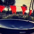 Red flags mark prohibited entry to a playground. A large bowl swing hangs from chains.
