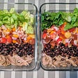 2 perfectly meal prepped lunches in rectangular tupperware. There is meat at the bottom, then beans, then onions & tomatoes, then lettuce