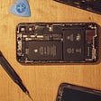 IMAGE: An Apple smartphone open and a screwdriver