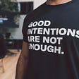 Black t-shirt reads: good intentions are not enough