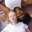 Two white and black women on the floor.