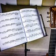 Sheet music on a music stand and a guitar