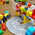 Lego creations of bridges over a toy road on a table.