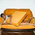 Woman Lying on the Yellow Couch and Smiling