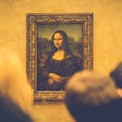 An image of the Mona Lisa on the wall, with heads of spectators seen out of focus from behind.