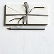 Joanna Kosinska via Unsplash; bundle of letters tied with a bow and a pencil