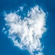 Heart-shaped white cloud against a blue sky.