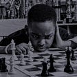 A chess prodigy staring at a chess board and the pieces
