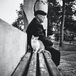 Old man sitting on a bench with his cat