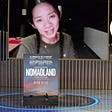 Chloe Zhao accepts the Golden Globe on a TV screen on the Globe’s stage, with Local’s logo on top of the award presenter’s head. A poster for Nomadland sits at the bottom of the screen.