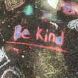 Be kind written with colorful chalk on asphalt