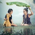 A woman and child smiling heartily in the rain—5 Happiness Quotes to Share With You Today by Paul Myers