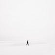 a white screen with a small dark image of a person walking auden wright medium