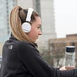 Photo of a woman wearing white headphones