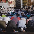 Muslims praying on Friday in Dubai. The congregation has spilled onto the road outside of the mosque.