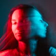 A young woman shaking her head. The image is blurry and is edited to be red and blue.