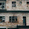 An old building that looks abandoned with many windows broken
