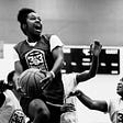 Girl basketball player going in for the dunk with an expression of joy and delight