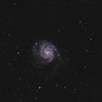 Photo of a galaxy pinwheel on starry sky.
