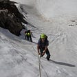 Two climbers ascending a snowfield