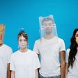 Four people wearing white t-shirts with various odd head coverings (paper bag, plastic bottle and plastic container). One is wearing a yellow face mask.