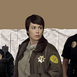 A graphic of Athena, Jody, and Stef all standing in uniform against a brown background with some crumpled newspaper texture behind them.