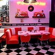 A diner setting with a vinyl round booth.