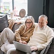 Older couple at home looking at a laptop screen.