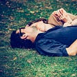 Couple cuddling in park on grass