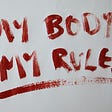 White background with red painted words: My Body My Rules.